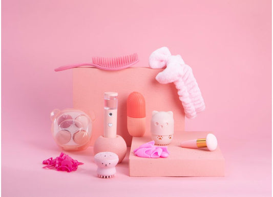 Conjunto de accesorios de belleza, maquillaje y cosmética, todos de color rosa, frente a fondo rosa