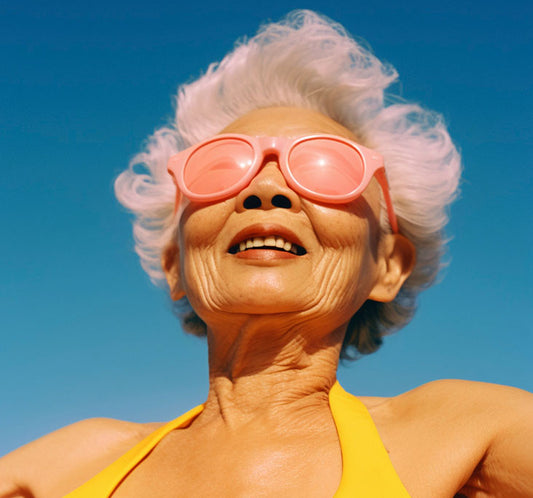 Mujer oriental con pelo blanco en bañador y con gafas de sol rosas